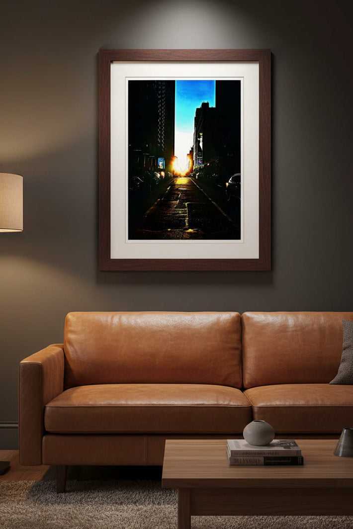 Fine art photography print of a golden Manhattanhenge sunset aligning down a dark New York City street canyon between skyscrapers.